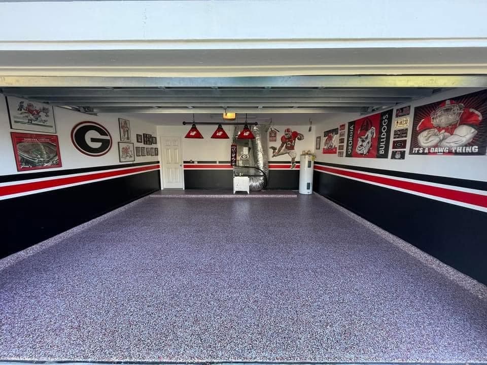 Grey flake garage floor beneath red, black and white walls decorated with Georgia Bulldogs memorabilia.